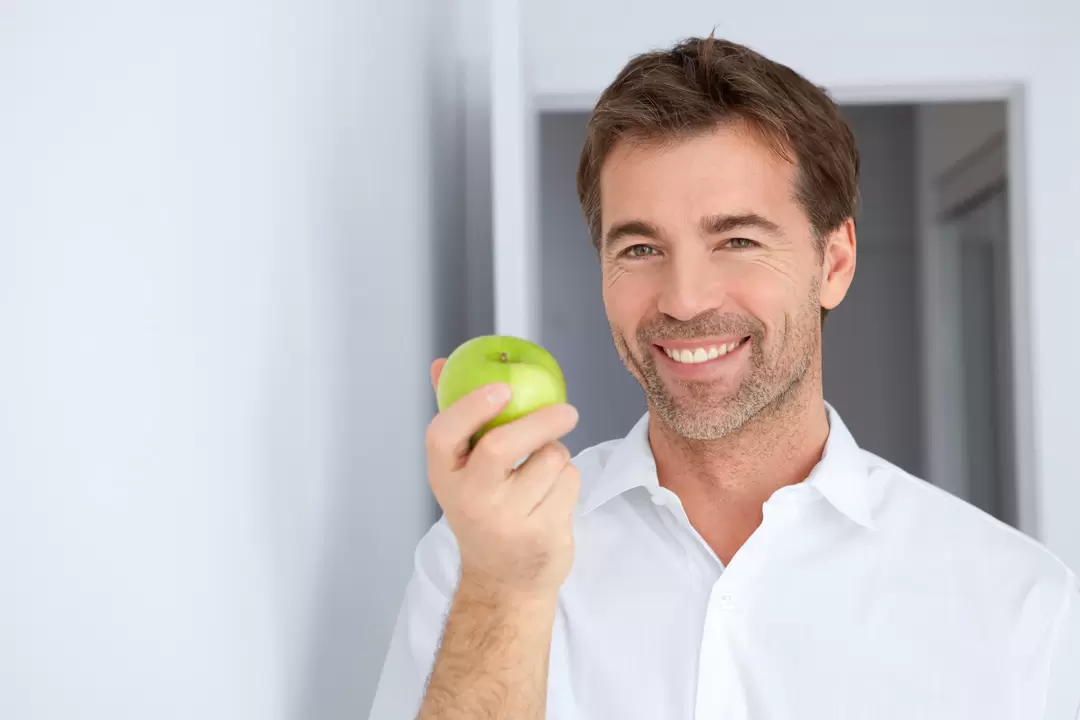 A man eats an apple to increase his potency